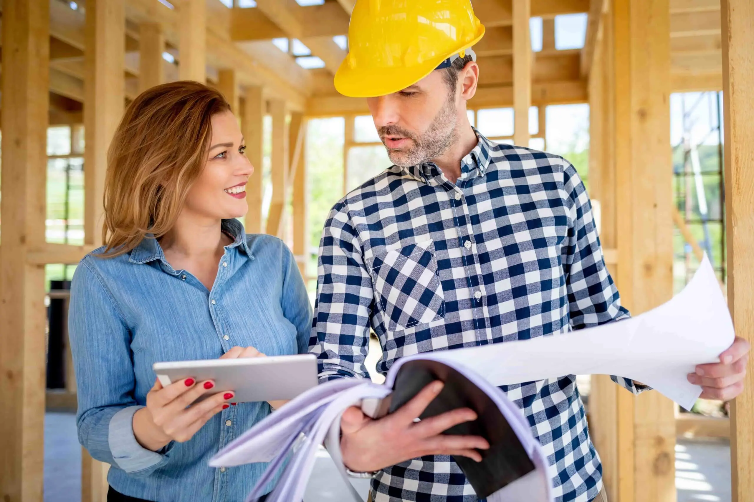 Female homeowner consults blueprints with Architec