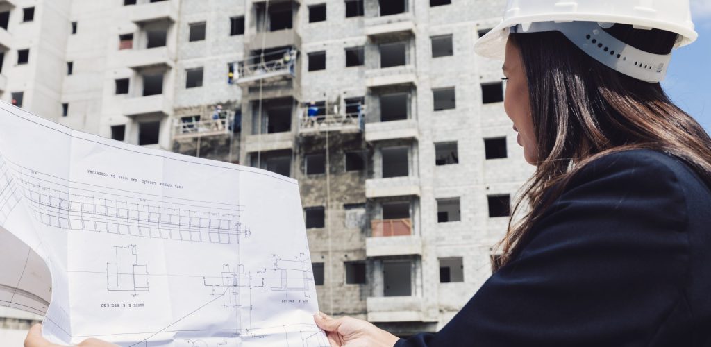 african-american-lady-safety-helmet-with-paper-plan-near-building-construction african-american-lady-safety-helmet-with-paper-plan-near-building-construction