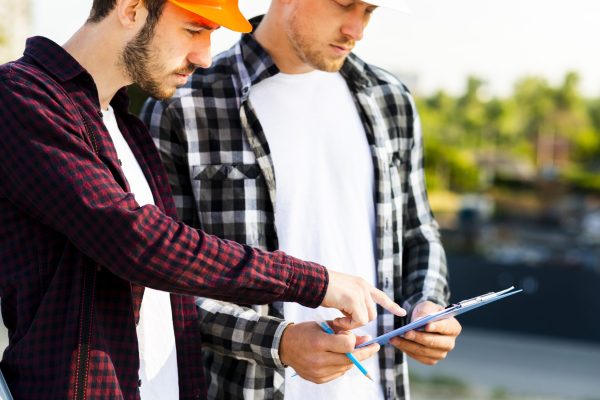 close-up-engineer-architect-looking-clipboard